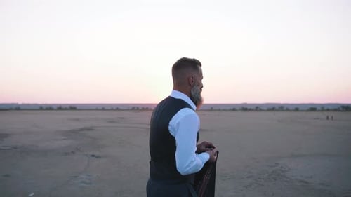 Handsome Bearded Mature Man in Suit Walking Outdoors on Beach During Sunset Slow Motion