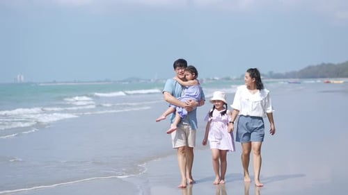 4K Happy Asian family walking and playing together on the beach on summer vacation