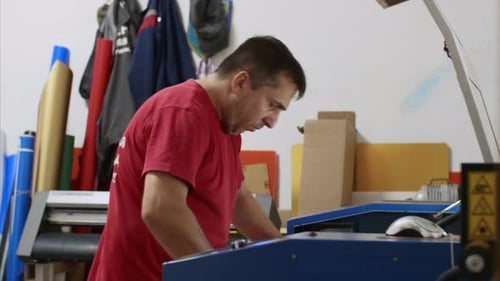 Trabajador de tipografía que imprime en imprenta moderna en hojas grandes en el taller