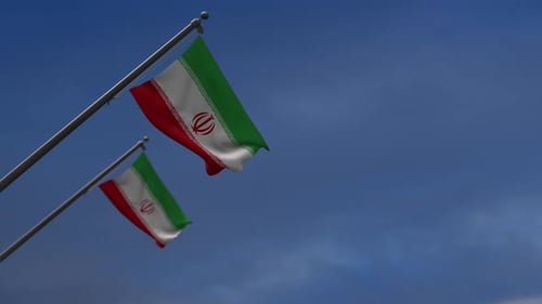 Iranian Flag Waving in Wind Against Blue Sky