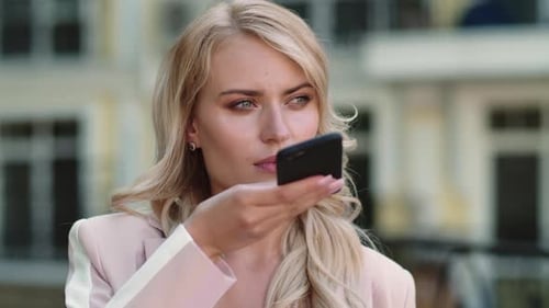 Woman Using Voice Command on Mobile Phone Outdoors