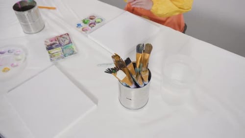 Petite fille peignant avec de la peinture acrylique sur toile avec sa mère pour un projet artistique d'apprentissage à distance