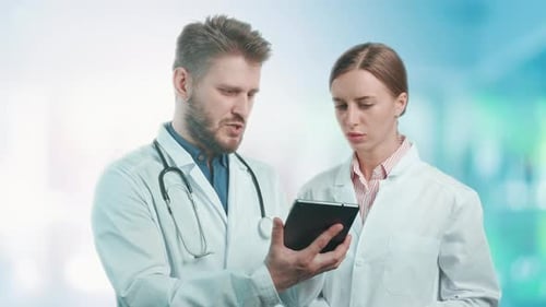 A Doctors are Talking and Checking Results on Digital Tablet in a Hospital