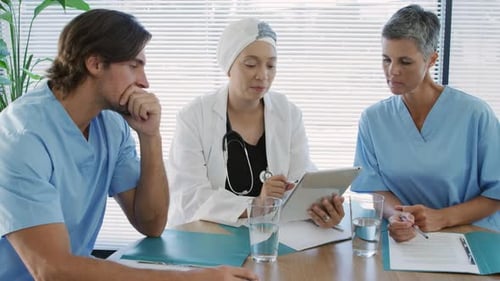 Medical Team Discussing Tablet in Healthcare Workplace