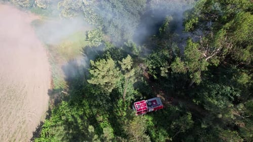 Fire Engine Sprays Water on Burning Forest