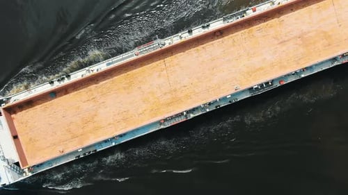 Long Brown Unloaded Freight Vessel Sails on Deep Water