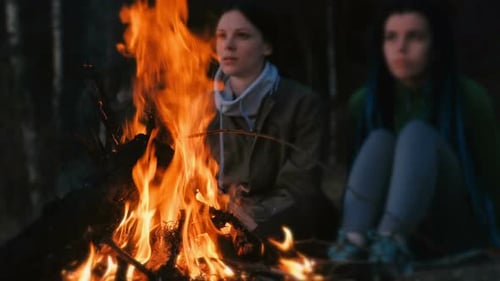 Two Women and Boy Look at the Fire on a Summer Evening. Family Holiday Weekend