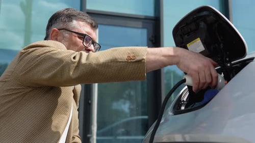 Man with Electric Car in Urban Environment