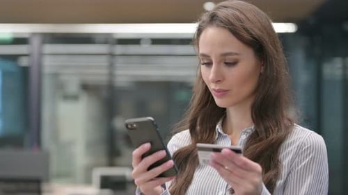 Woman using Phone and Credit Card for Online Shopping