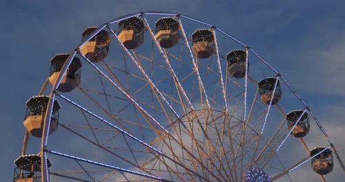 Riesenrad in Aktion vor blauem Himmel.