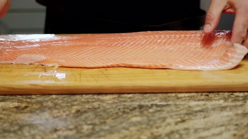 Close Up View of Cooks' Hands Cuts the Fish Into Pieces for Further Processing