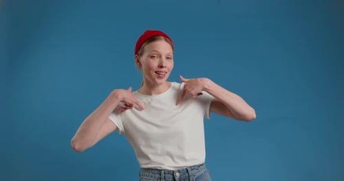Enthusiastic Woman Pointing Downwards in Studio
