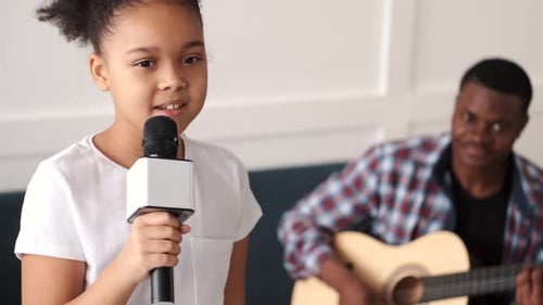 Adorable Girl Singing Song with Guitar Accompaniment