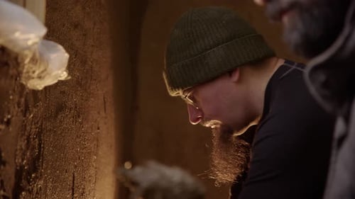 Men Plastering a Wall Indoors With a Tool