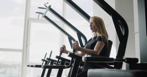 Young Active Athletic Blonde Girl Works Out in the Gym