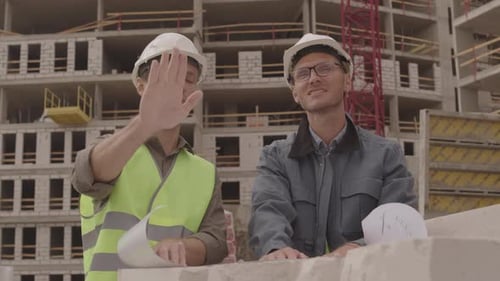 Engineers Reviewing Construction Plans at Building Site