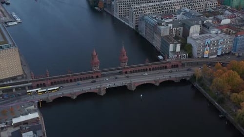 Vue aérienne lente et inclinée vers le bas sur le célèbre pont d'Oberbaum à Berlin, en Allemagne, avec un bus jaune et une voiture