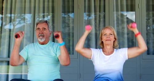 Senior Couple Exercising with Pink Dumbbells