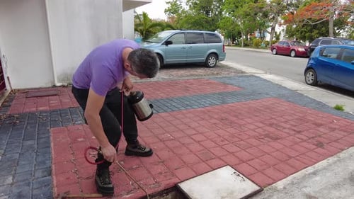 Man Sprays Concrete Container with Tank Sprayer