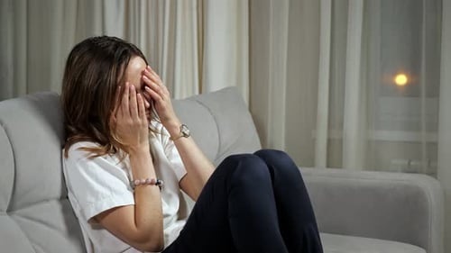 Woman Sitting on Sofa with Headache