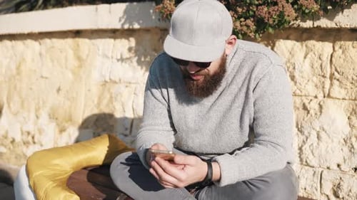Athletic Man Sits on a Bench in Spring