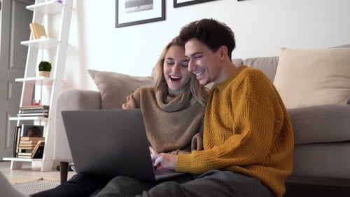 Smiling Couple Using Laptop Together at Home
