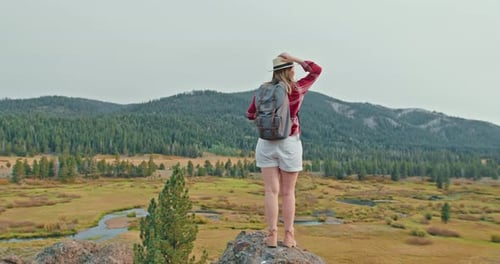 Traveler with Backpack in Red Classic Shirt Standing on Top of Rock on Fall Day