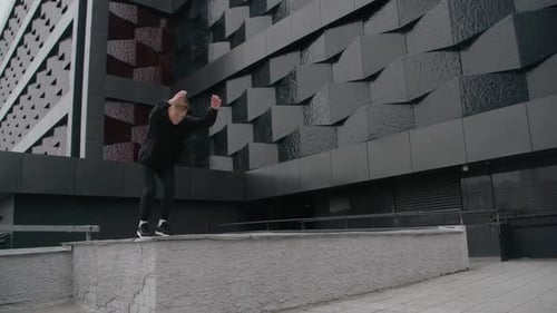 Young Man Does Flips and Jumps Parkour on Modern City Free Running in Slow Motion