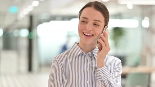 Woman Talking on Mobile Phone in Office Setting