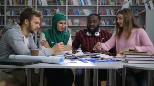 Étudiants multiethniques se préparant aux examens en bibliothèque