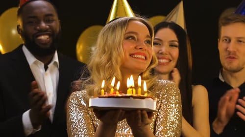 Woman Blows Out Birthday Candles with Friends