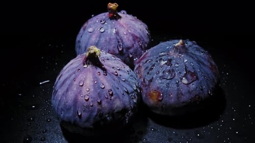 Fresh Figs with Dew Drops Close-up Rotates on Black Background