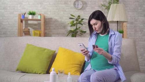Pregnant Woman Checking Pills on Smartphone at Home
