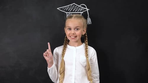 Girl Stands Before Chalkboard with Graduation Cap Drawing