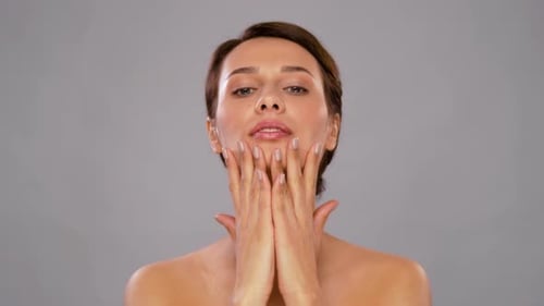 Glamorous Woman Performing Facial Massage for Skincare