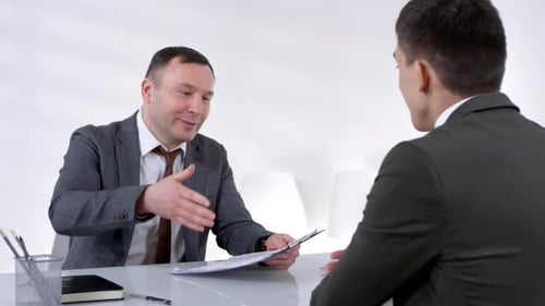 Men in Suits Discussing Business in Bright Office