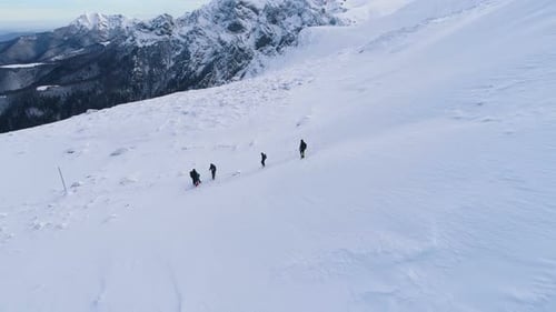 Eine Gruppe von Menschen wandert auf dem Schneehang in den bulgarischen Bergen