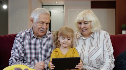 Girl and Grandparents Using Tablet Together at Home