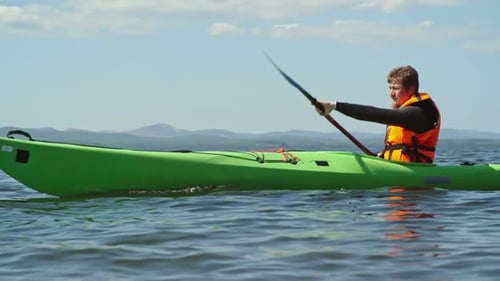 Man Paddling Kayak on Lake on a Sunny Day