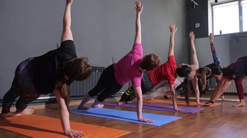 Women Performing Yoga Exercises in Yoga Studio