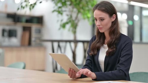Winning Businesswoman Celebrating Success on Tablet