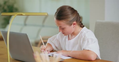 Child Studying with Laptop and Notebook at Home