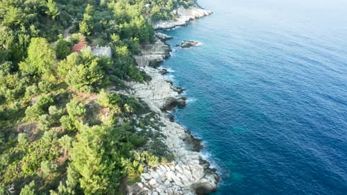 Drone Flying Over Rocky Coast Line with Turquoise Sea Water