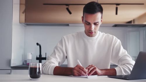 Young Caucasian Male Hand Writing with Pencil on the Book. Businessman Working with Data Information