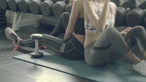Beautiful young asian woman relax drinking water with fresh after exercise in the gym.