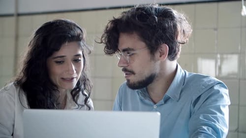 Front View of Focused Young Woman Talking with Confident Colleague