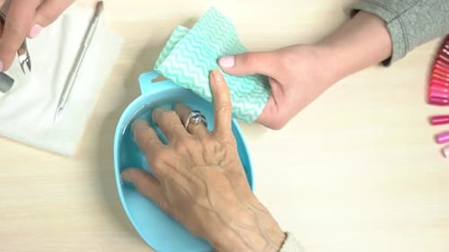 Manicure on Senior Woman's Hands Close Up