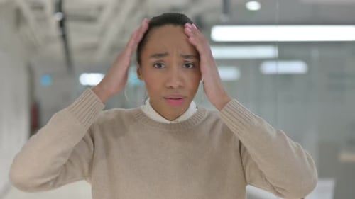 Worried Woman With Hands on Head in Office