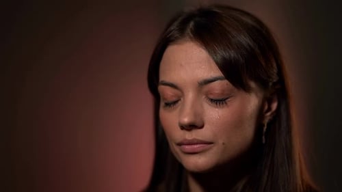 Mujer encantadora está llorando, primer plano de la cara en el estudio, tristeza y dolor, lágrimas en la mejilla