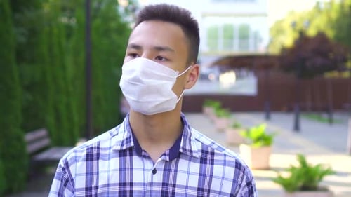 Portrait Young Asian Man in a Medical Mask on the Street in the Park Slow Mo
